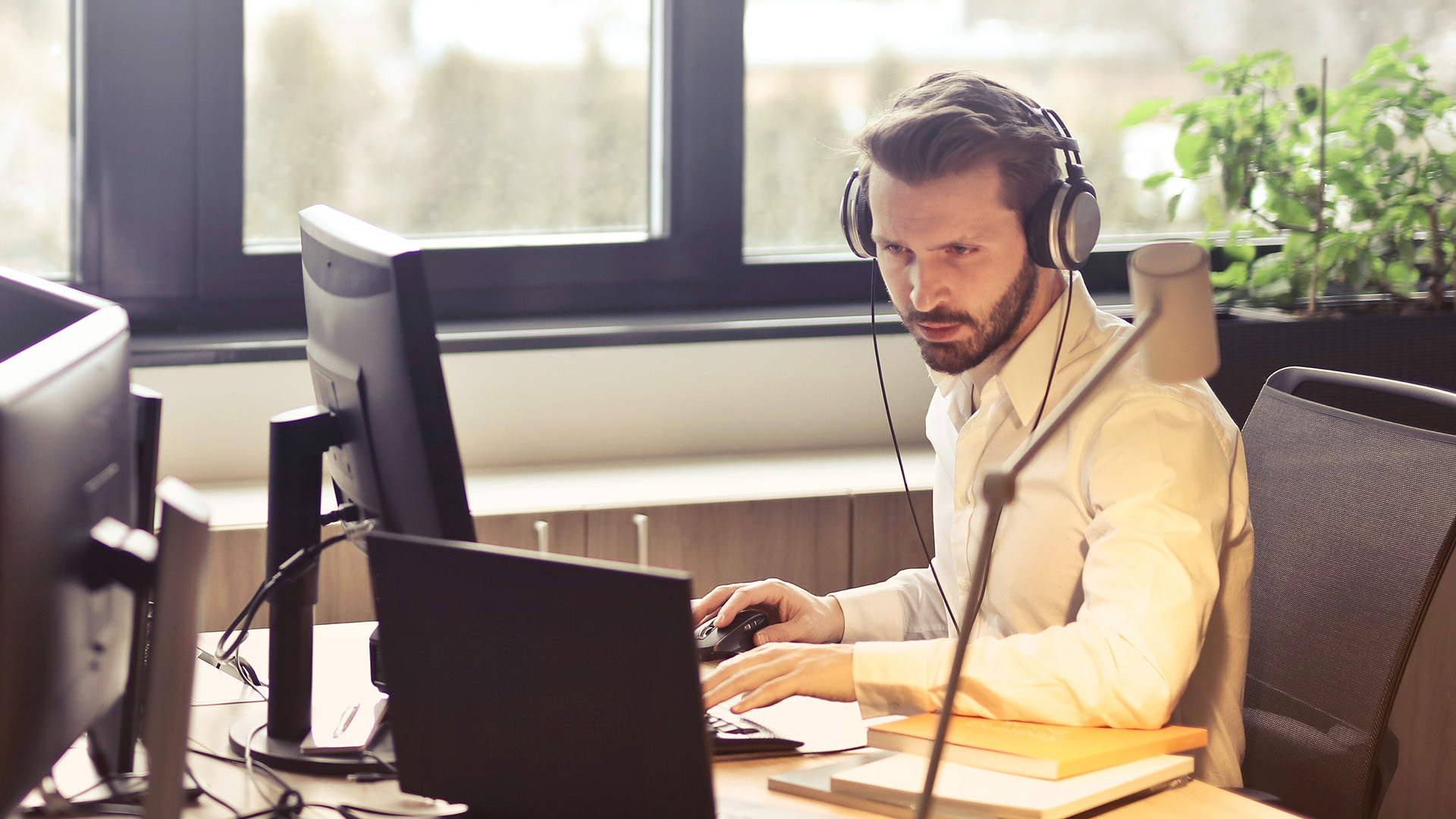 Business man using a computer with headphones